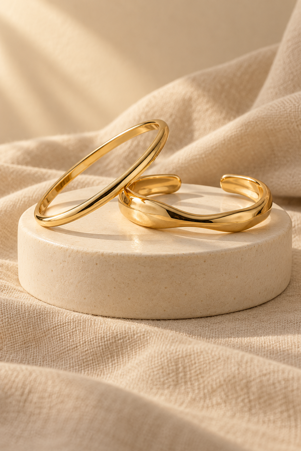 Two gold-tone bracelets in warm light